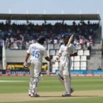 Indian Test batsmen celebrating partnership with handshake